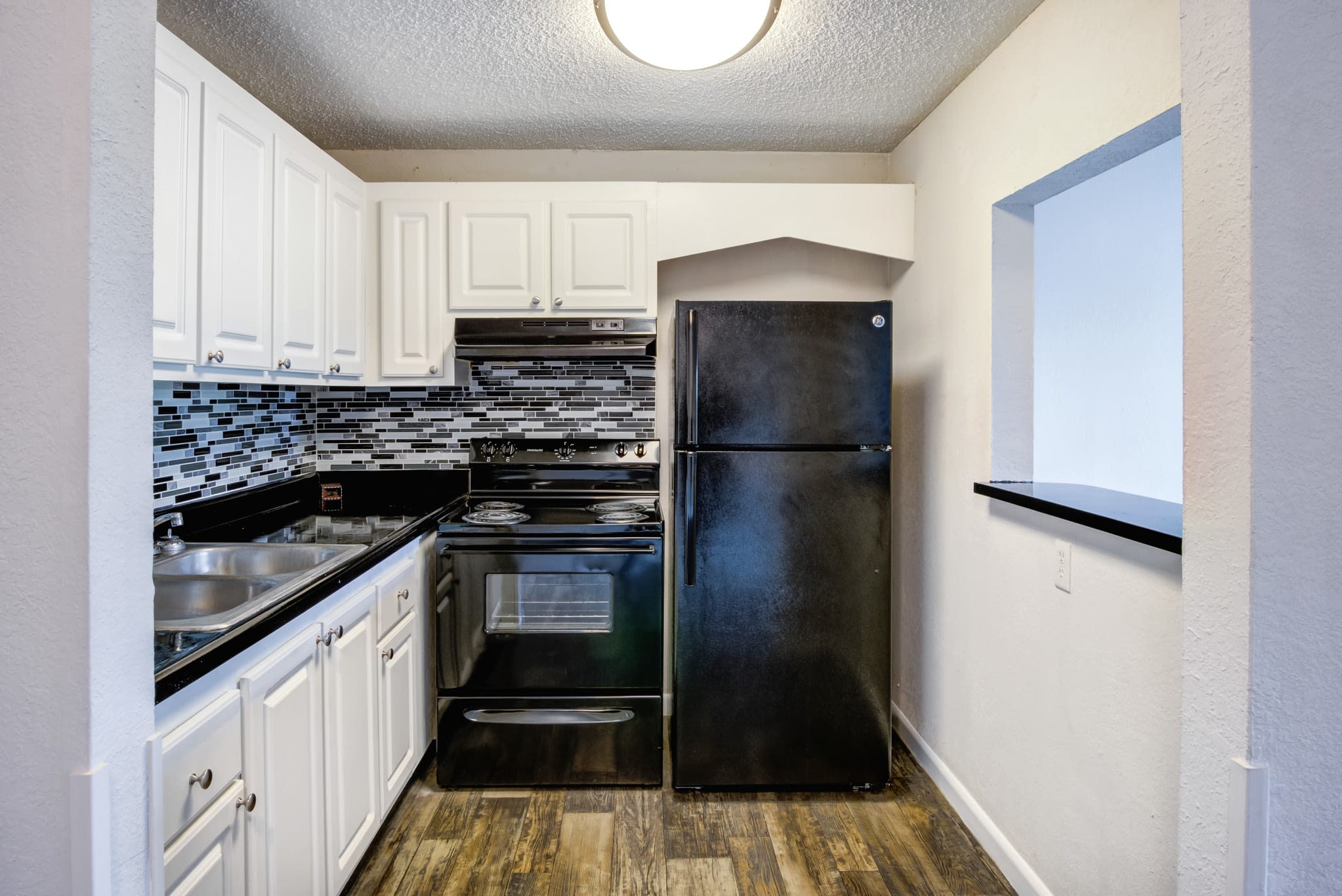 Apartment kitchen with a tile backsplash at Coronado Springs in Palm Springs, Florida