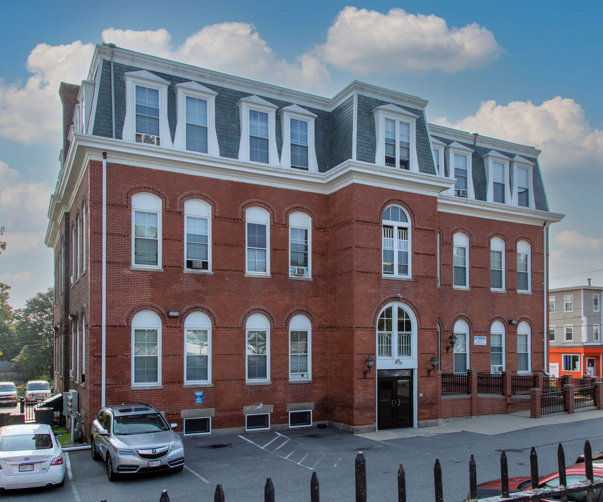 Building exterior with maroon accent and multiple windows at Acushnet Commons in New Bedford,Massachusetts