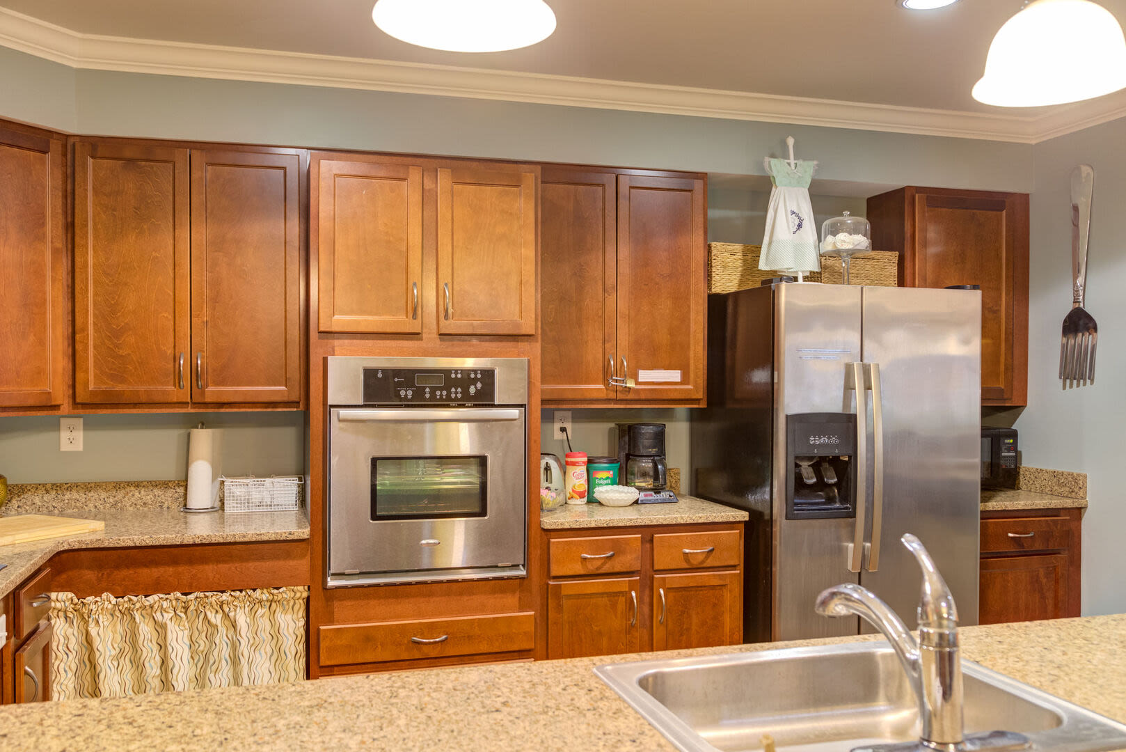 Clubhouse kitchen with wood finish cabinetry and modern kitchen appliances at Barstow Village in Hanover, Massachusetts
