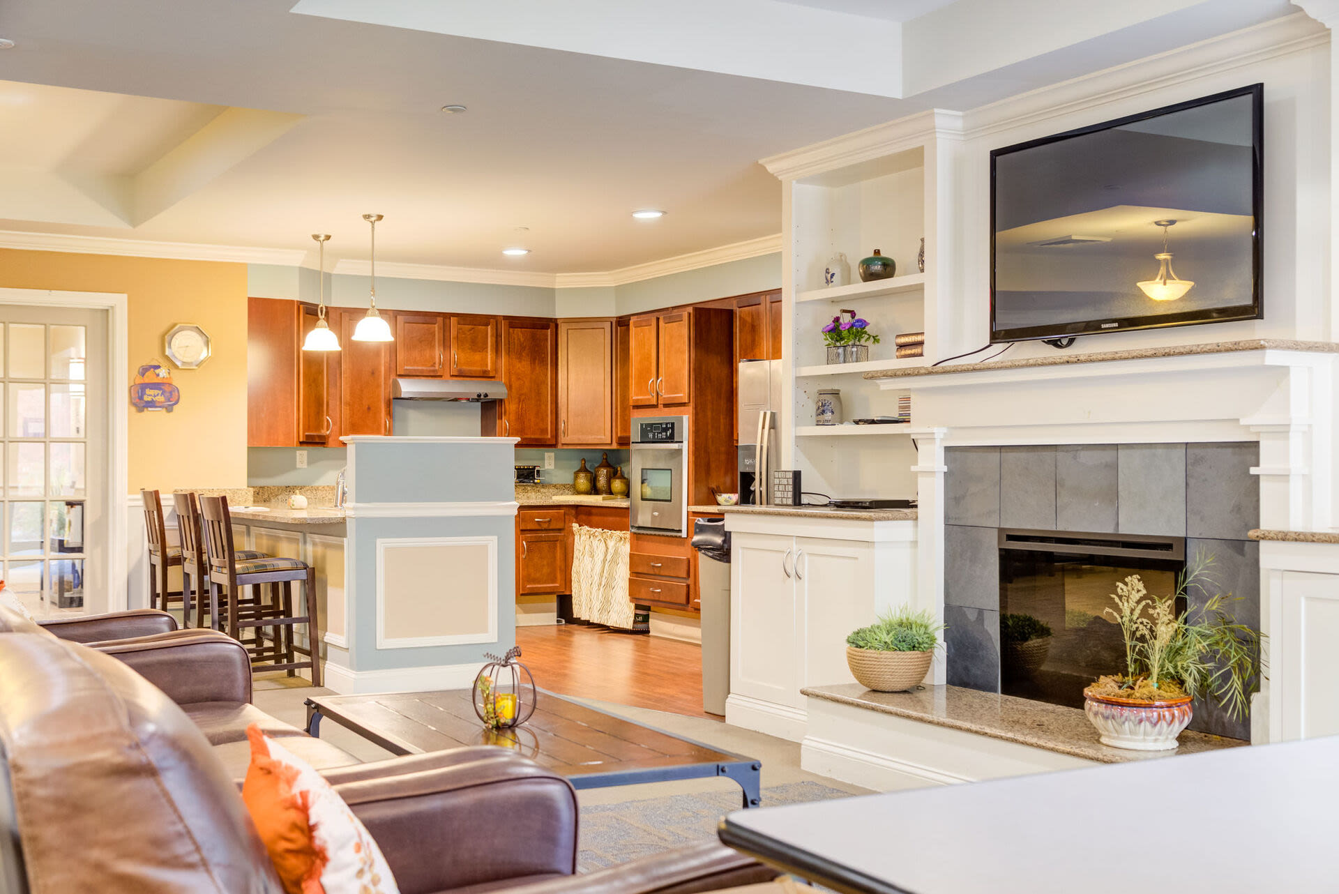 Community gathering space with fireplace and TV at Barstow Village in Hanover, Massachusetts