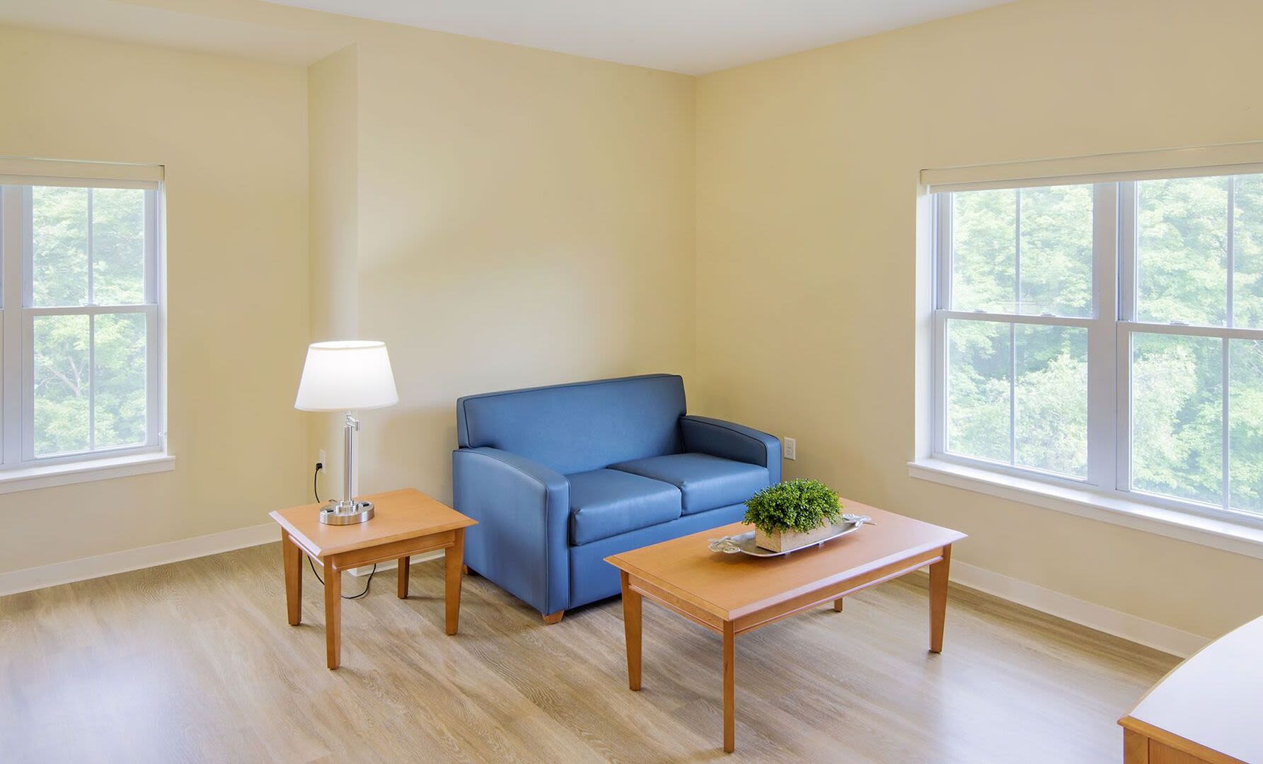 Spacious living room with couch, coffee table and wood flooring at Bedford Green Apartments in Bedford, Massachusetts