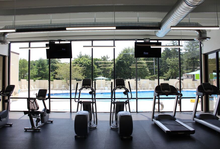 Community fitness center with treadmills and view to swimming pool at Braintree Village in Braintree, Massachusetts