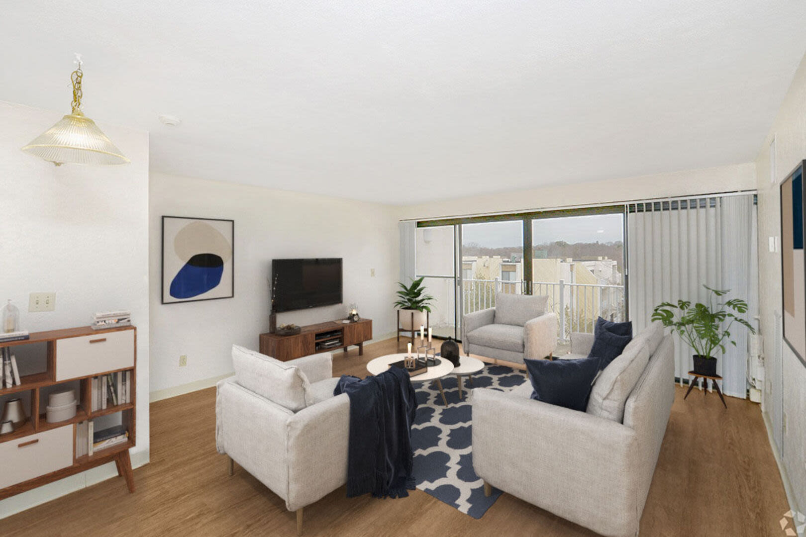Spacious living room with couch, flat screen television and access to patio at Braintree Village in Braintree, Massachusetts