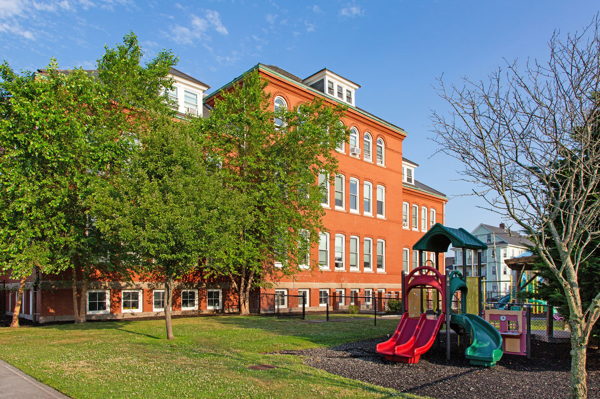 Exterior view of the building with playground at Ingraham School in New Bedford, Massachusetts