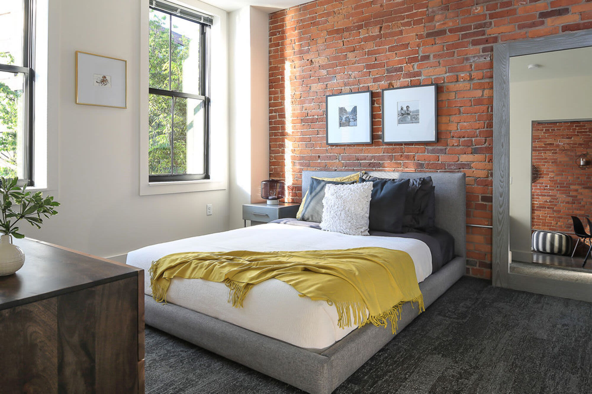Bedroom with large bed, paintings and window at J.M. Lofts in Haverhill, Massachusetts