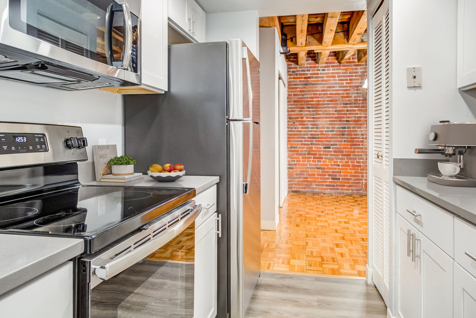 A modern kitchen showcasing the wooden cabinetry and hardwood flooring at Mercantile Wharf in Boston, Massachusetts