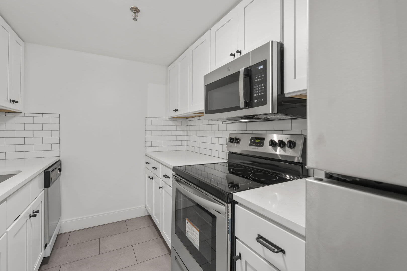 Apartment kitchen with stainless-steel appliances and wooden cabinetry at Mercantile Wharf in Boston, Massachusetts