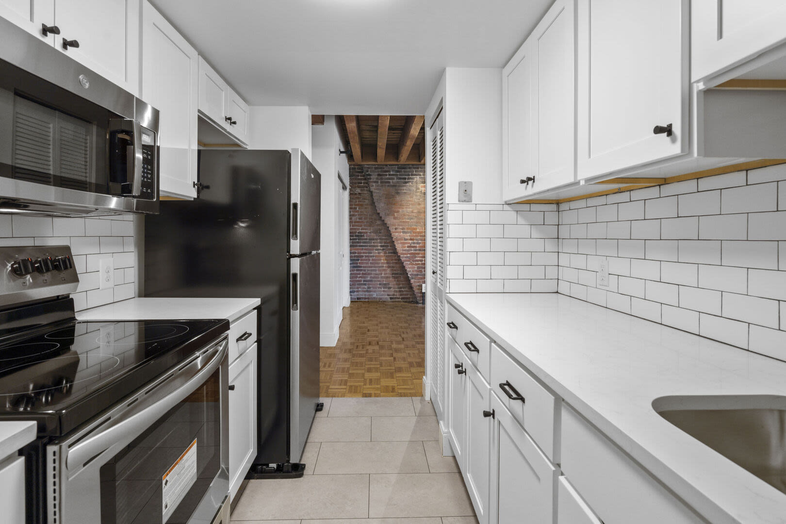 Fully-equipped kitchen with white wood cabinets at Mercantile Wharf in Boston, Massachusetts
