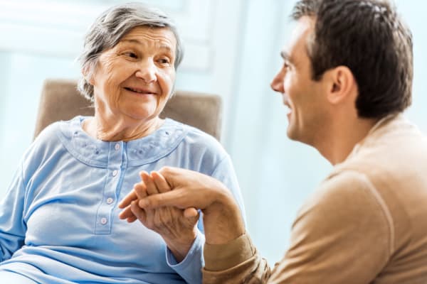 Resident holding hands with her son at a Living Care Lifestyles community