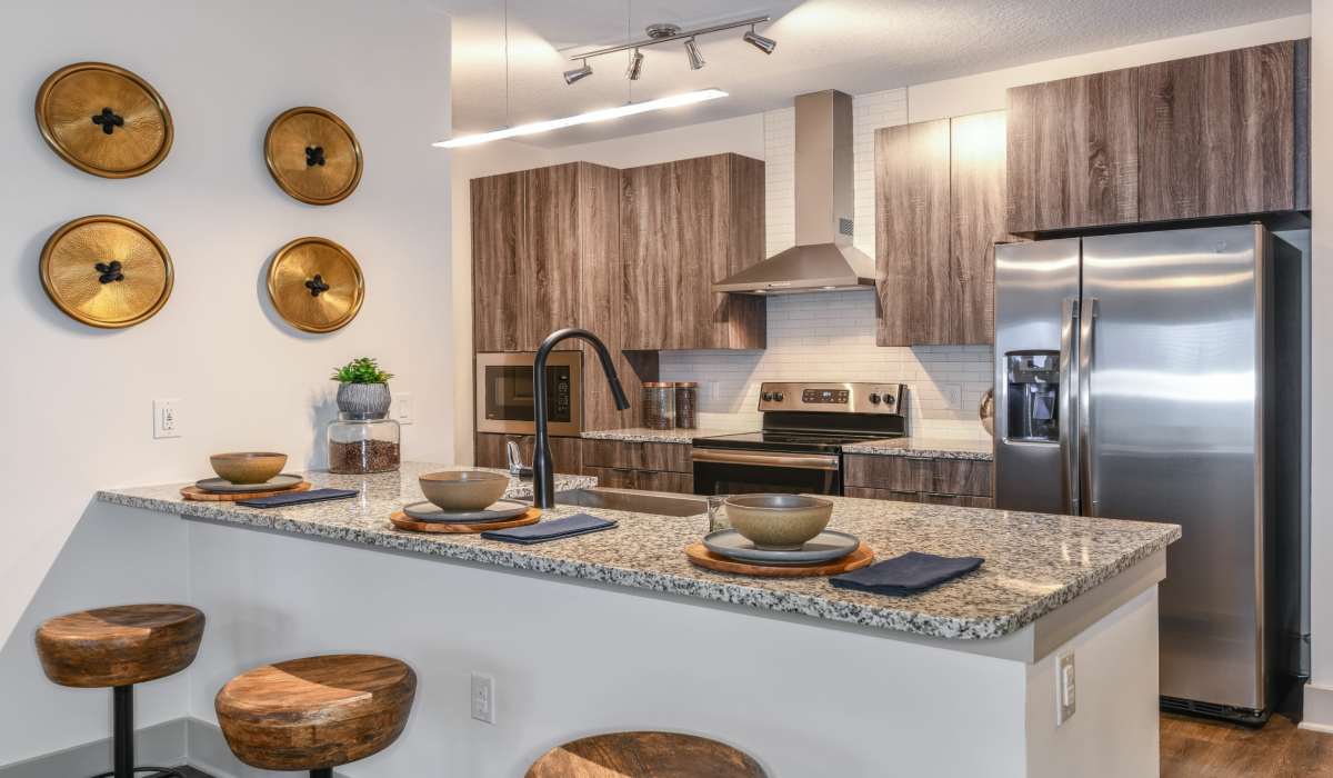 Modern apartment kitchen with counter seating and granite counters at Soba Apartments in Jacksonville, Florida