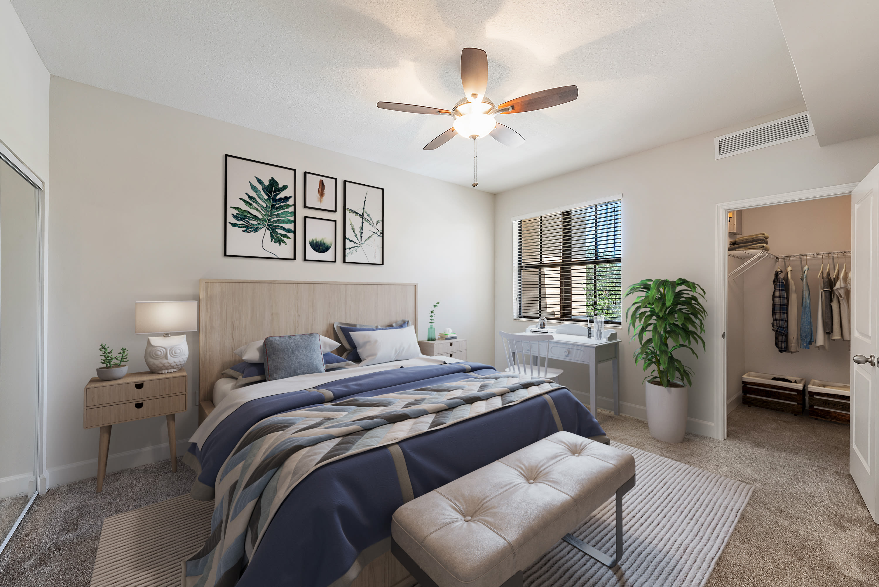 Spacious model bedroom with a desk by the window and a large walk-in closet at The Residences at Lakehouse in Miami Lakes, Florida