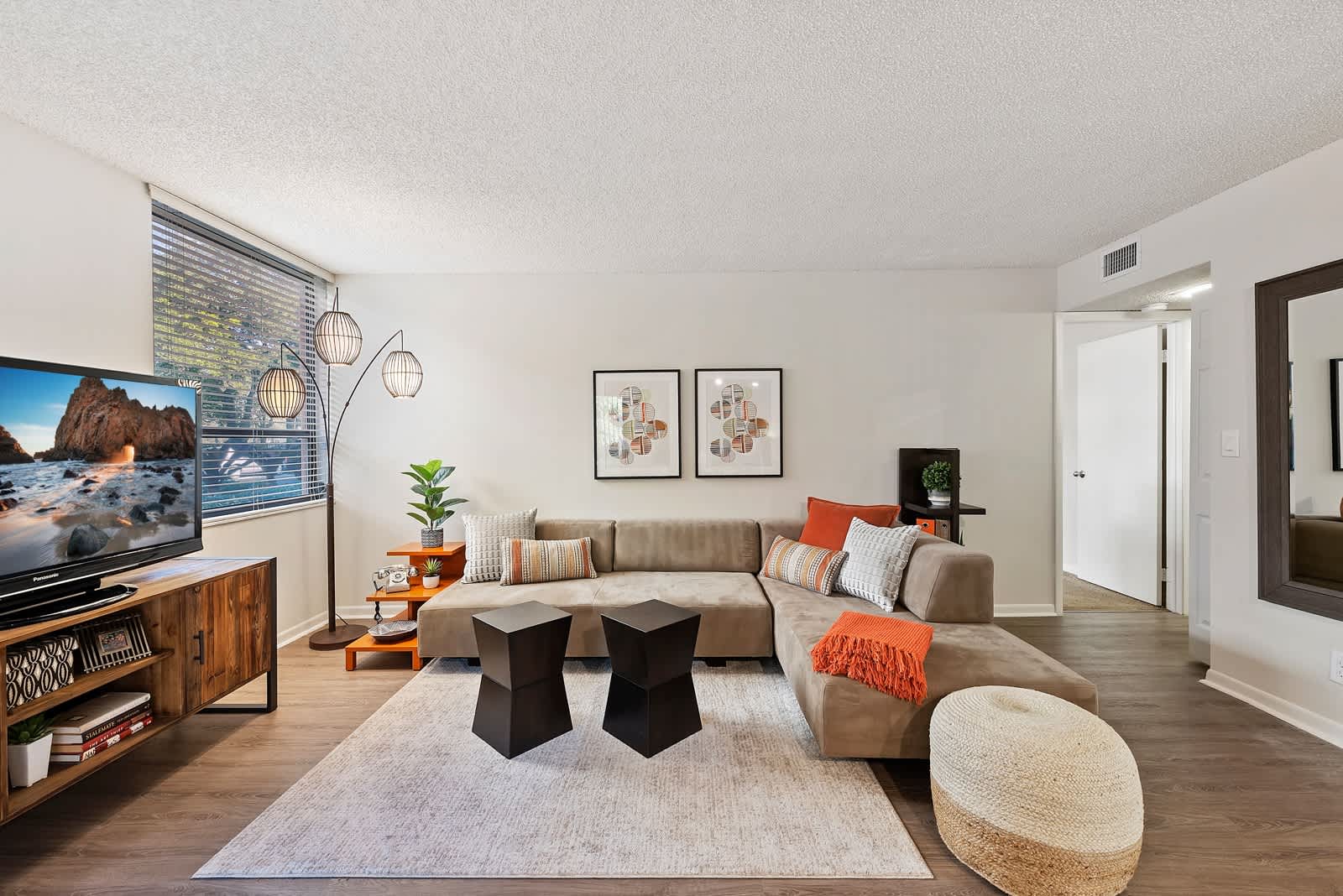 Model living room area with modern furnishings at New Barn Apartments in Miami Lakes, Florida