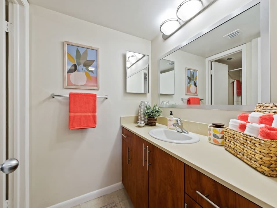 Model bathroom with ample cabinetry at New Barn Apartments in Miami Lakes, Florida