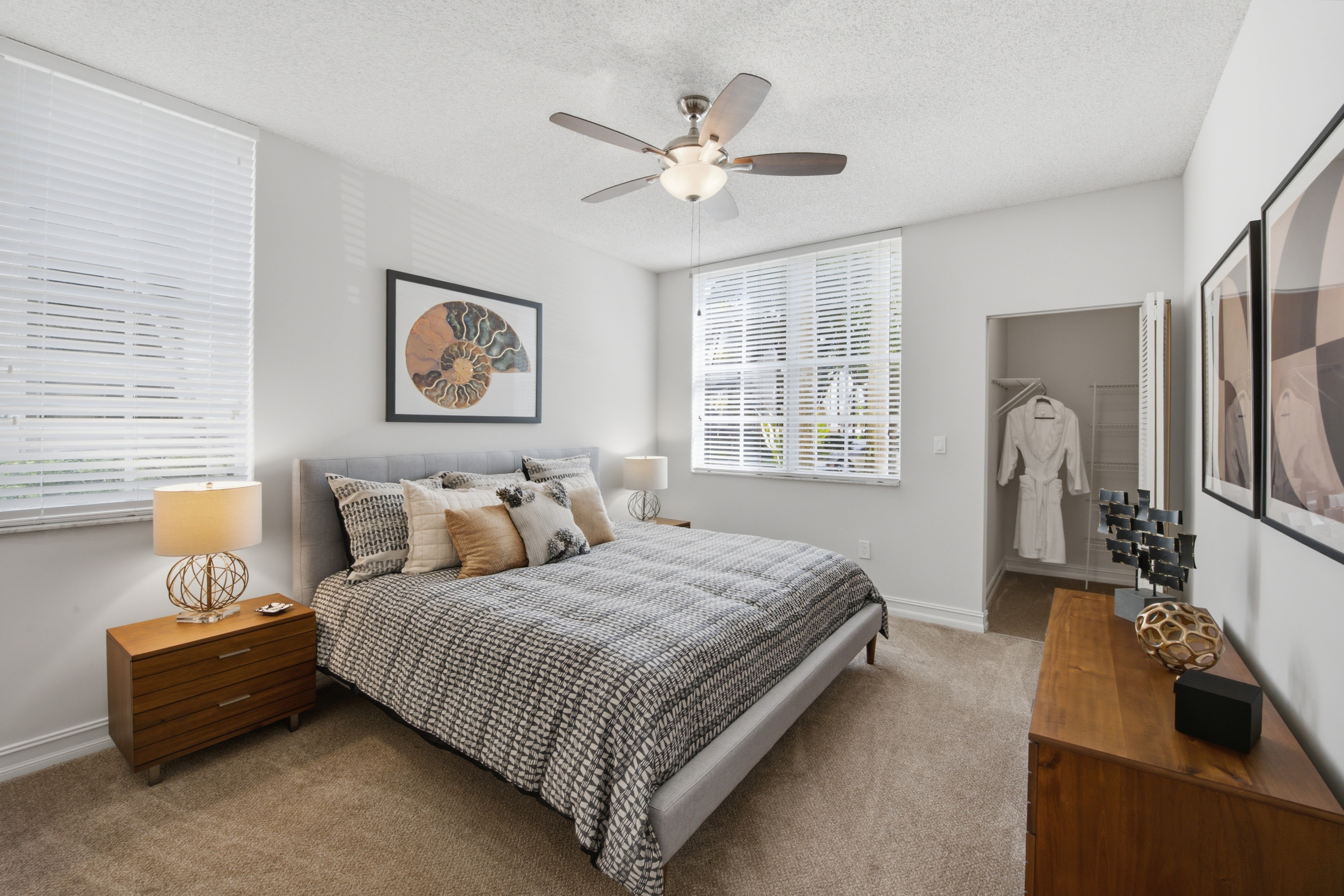 Beautiful model bedroom with a ceiling fan and plush carpeting at Fountain House Apartments in Miami Lakes, Florida