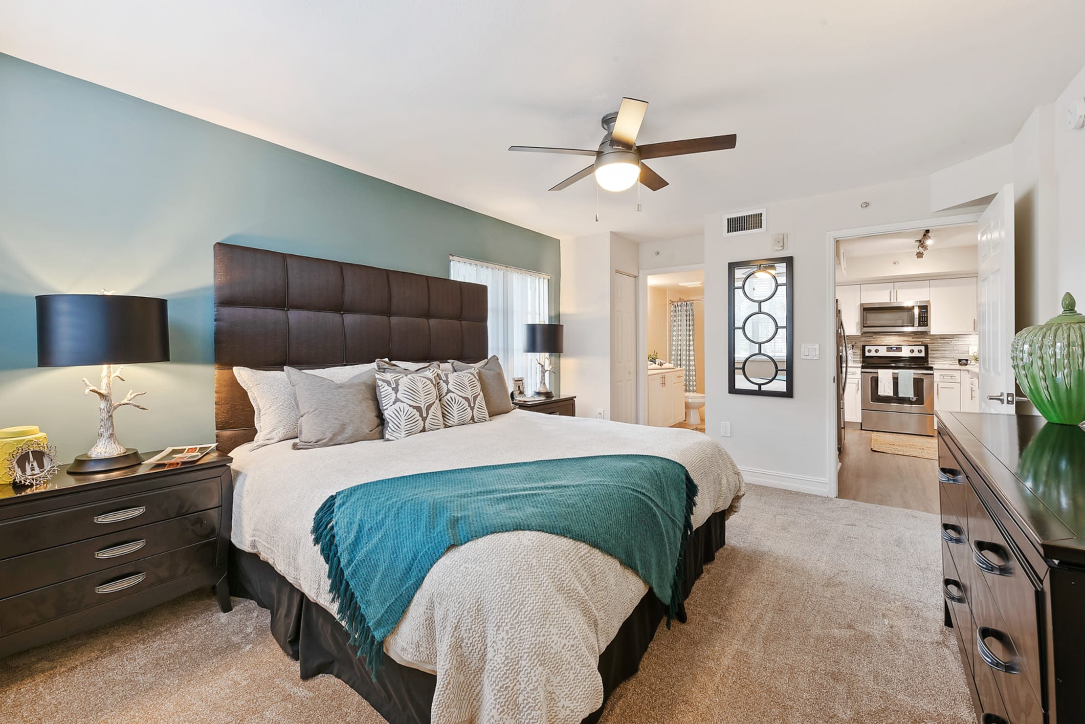Beautiful model bedroom with a ceiling fan and plush carpeting at Crescent House Apartments in Miami Lakes, Florida