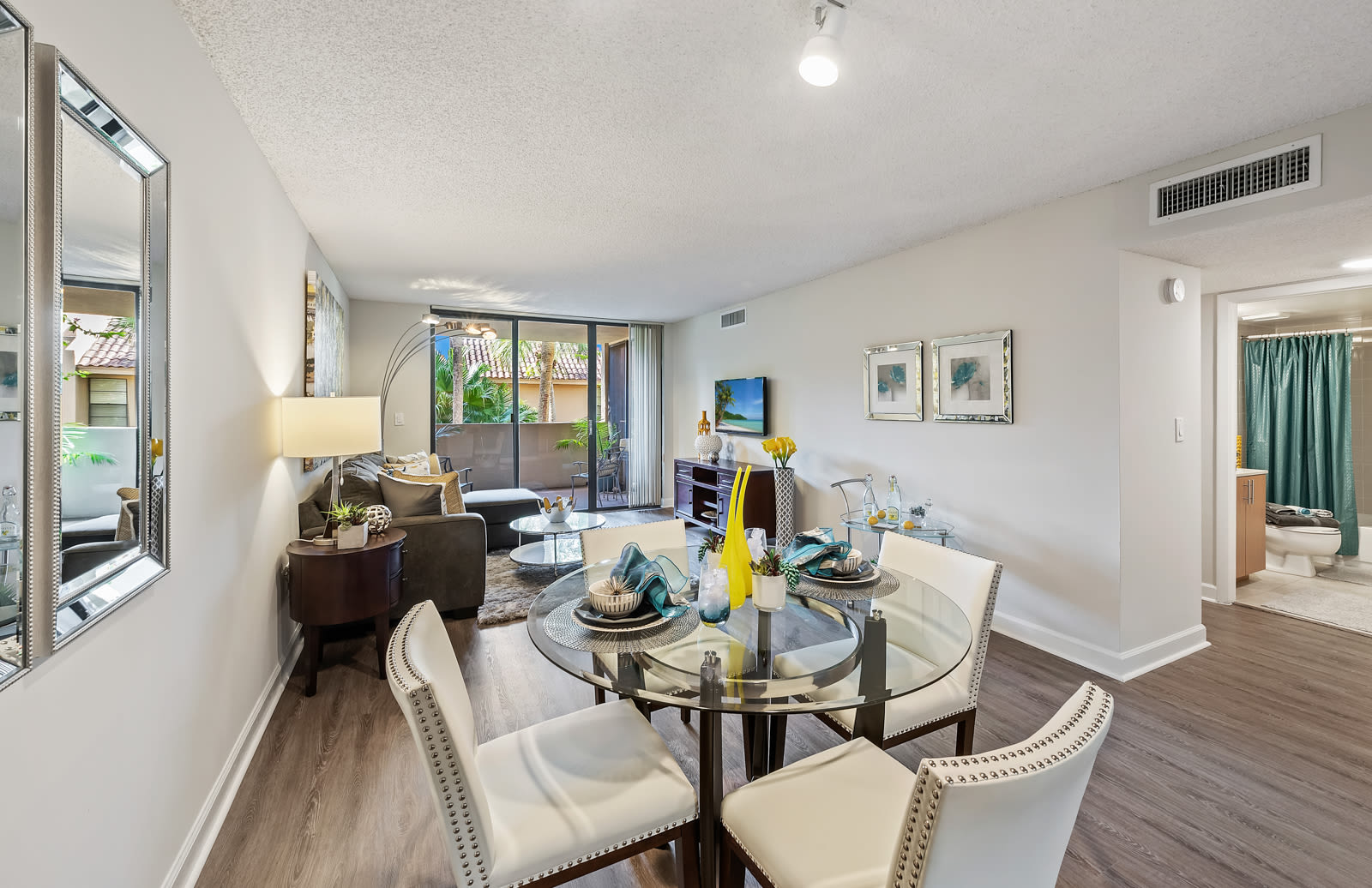 Dining and living area with wood-style flooring and plenty of natural light at Meadow Walk Apartments in Miami Lakes, Florida