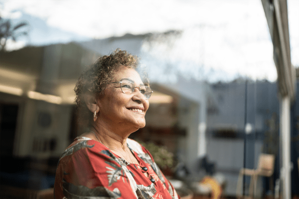 A resident smiling while enjoying a view out of her window