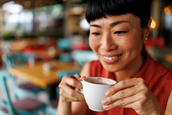 Woman smiling while holding a coffee cup near Dakota at Hillcroft in Houston, Texas