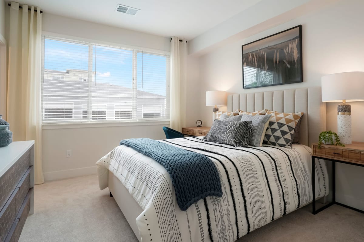 Apartment bedroom with bright windows at Enova in Commerce City, Colorado
