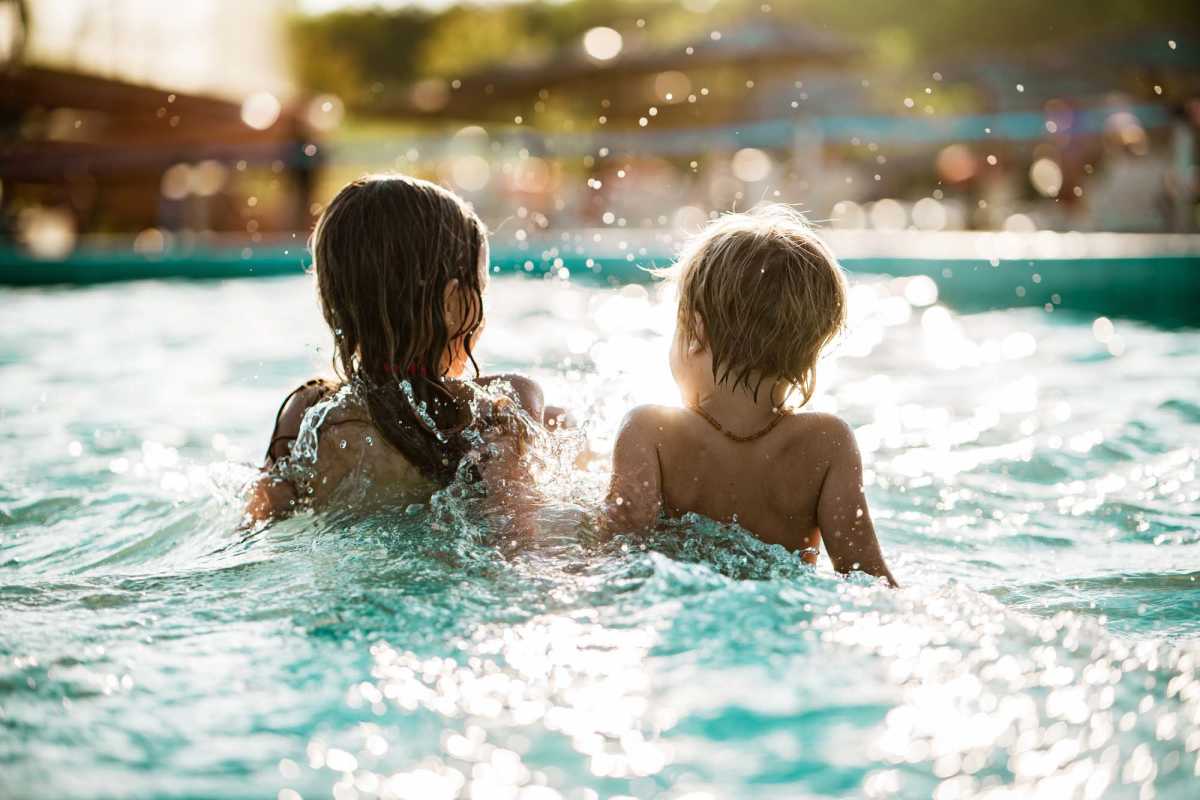 Children playing in a sparkling pool, splashing water around at Standard at Royal Lane in Dallas, Texas