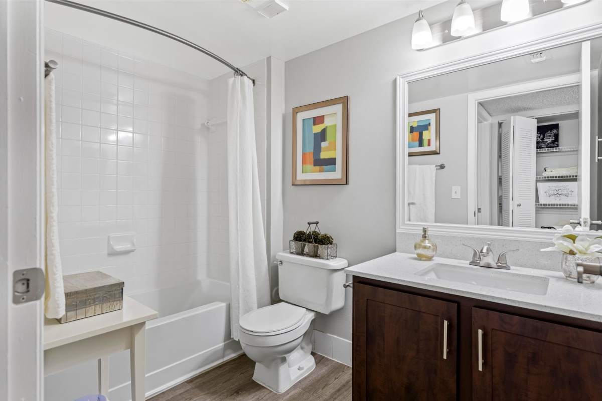 Bathroom with a bathtub and large mirror at Centro at Davie Apartments, Davie, Florida