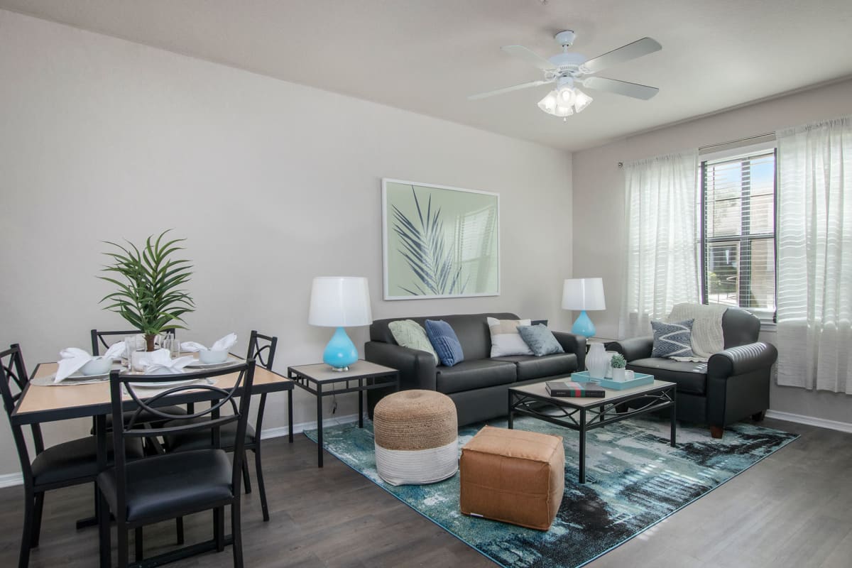 Cute living room with wood style flooring and a ceiling fan to stay cool at The Ivy in Tampa, Florida