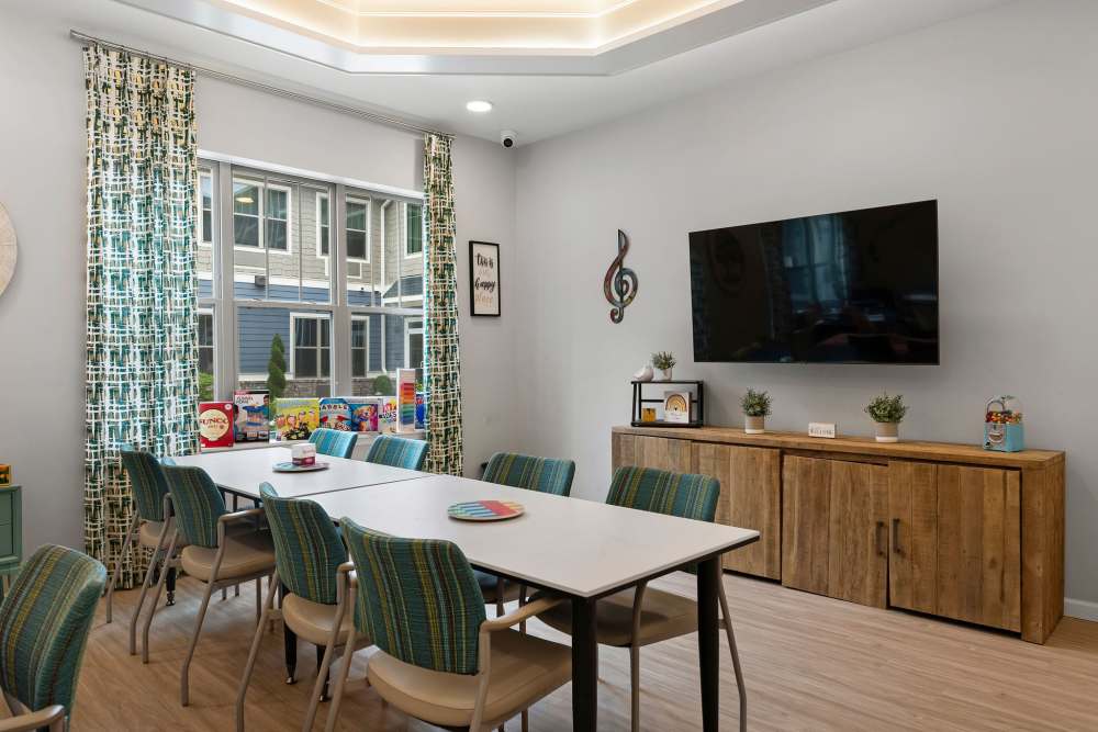 Community common area with chairs and table and flat screen television at The Barclay at Whiskey Road in Aiken, South Carolina