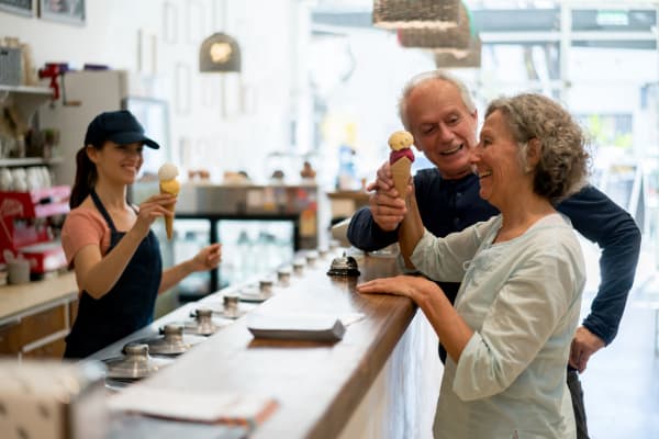 A resident handing an ice cream cone to his wife at a local ice cream shop