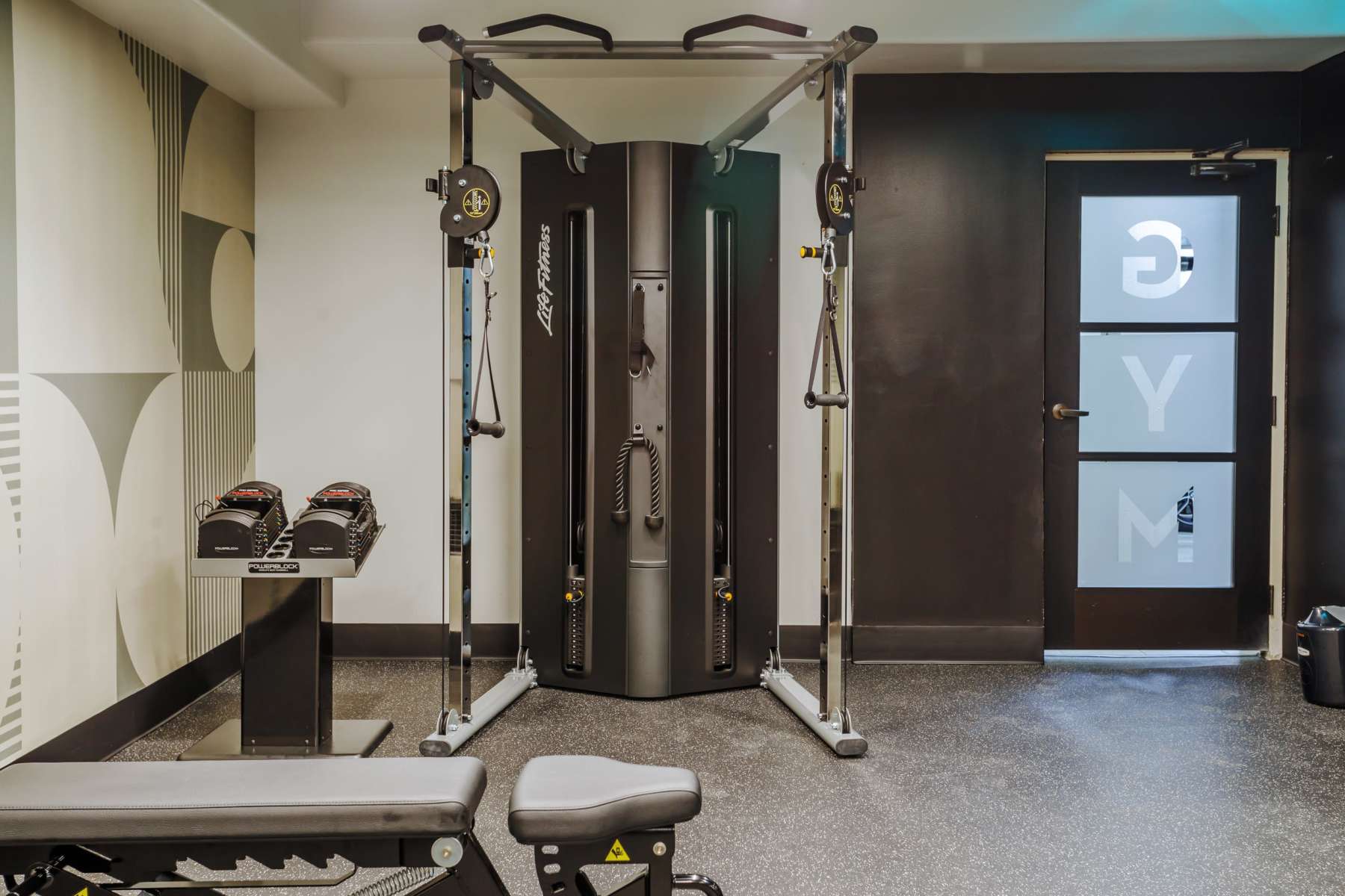 Gym with cable machine, dumbbells and bench at Luxe Villas in Brentwood, California
