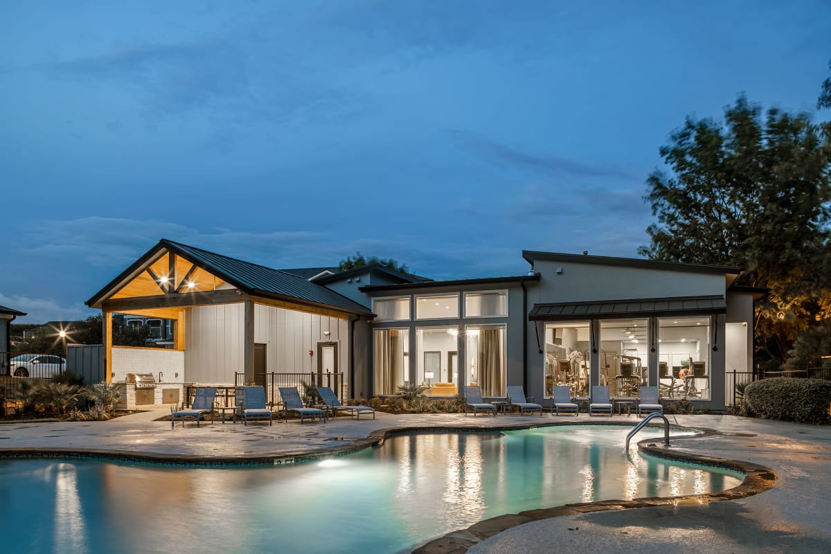 Swimming pool with a row of sunchairs nearby at Marquis at Crown Ridge in San Antonio, Texas