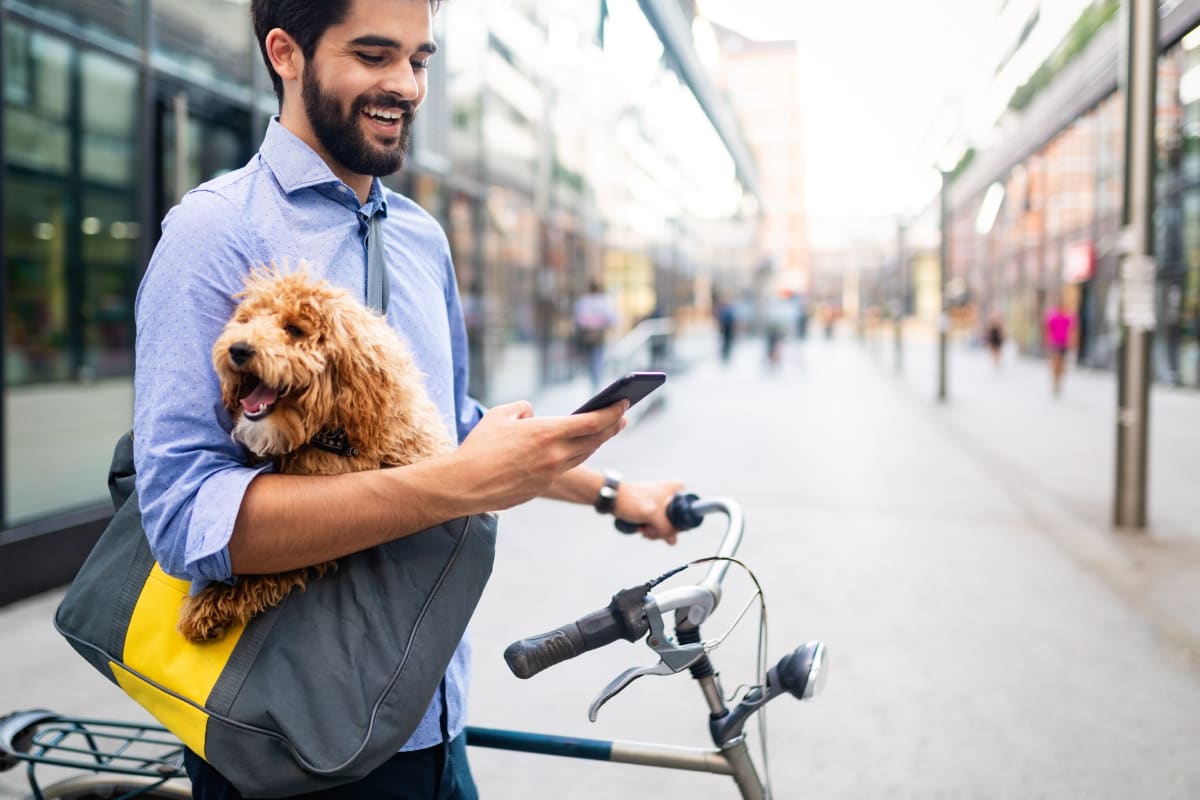 Resident with their dog in a messenger bag outside of MOD Apartments in Seattle, Washington
