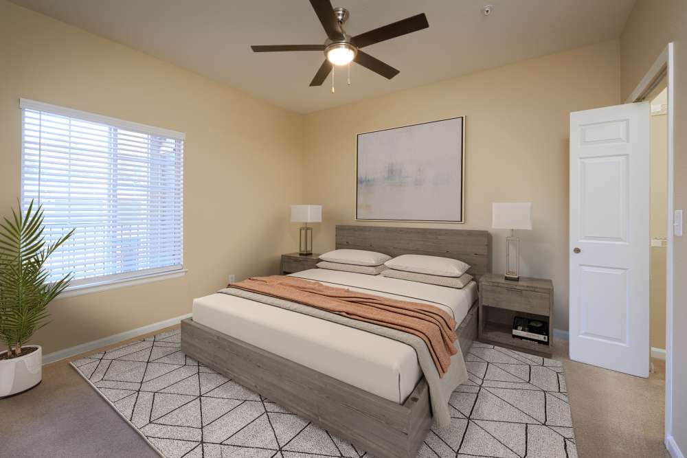 Spacious bedroom with a bed and large windows at Skyecrest Apartments in Lakewood, Colorado