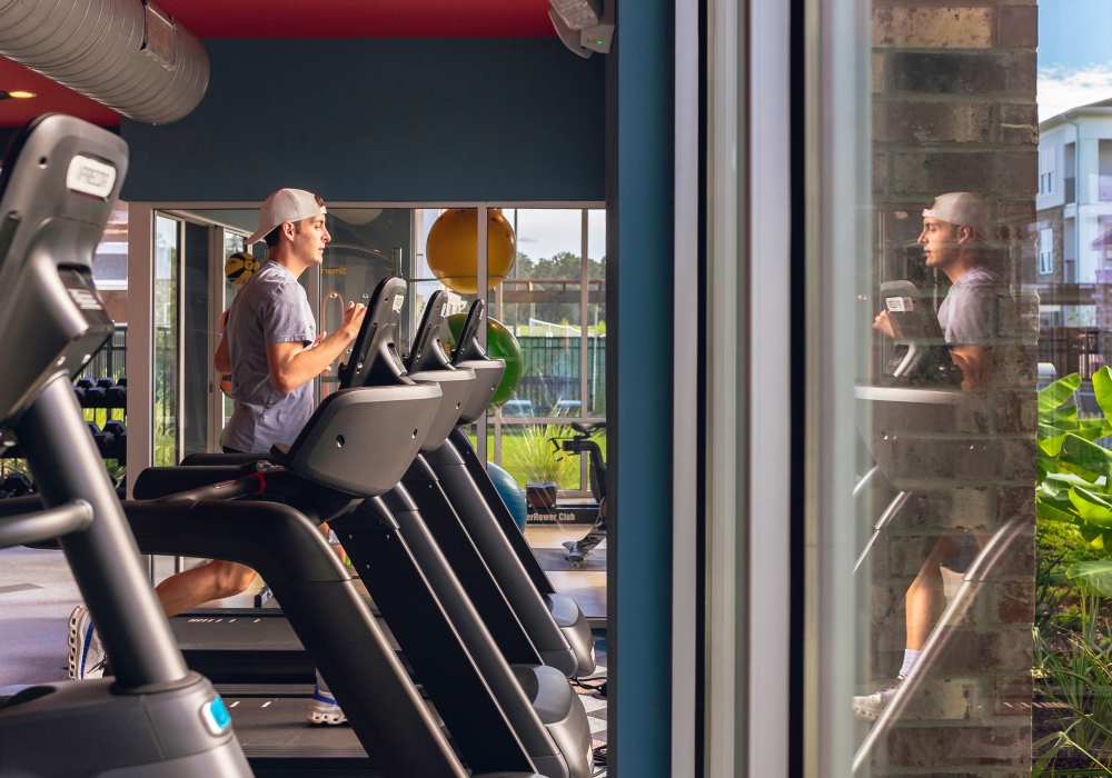 Resident in a community fitness center at The Waters at Promenade in Marrero, Louisiana