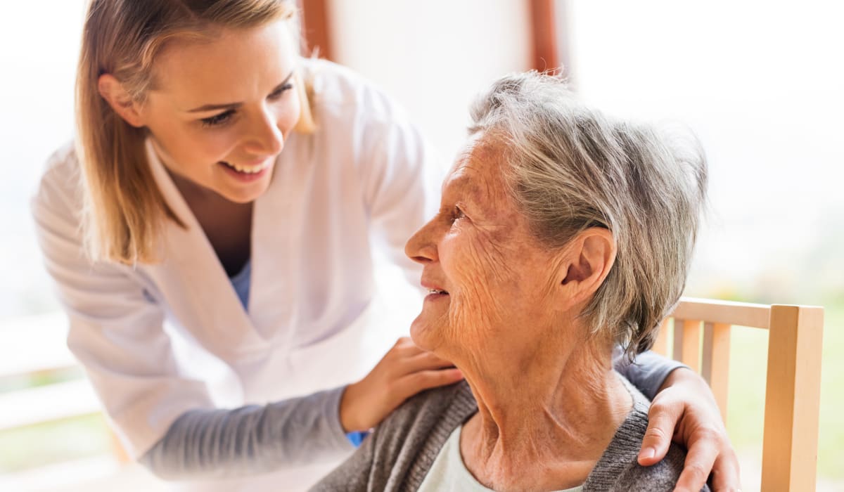 A staff member checking in on a resident at CERTUS Premier Memory Care Living in Vero Beach, Florida