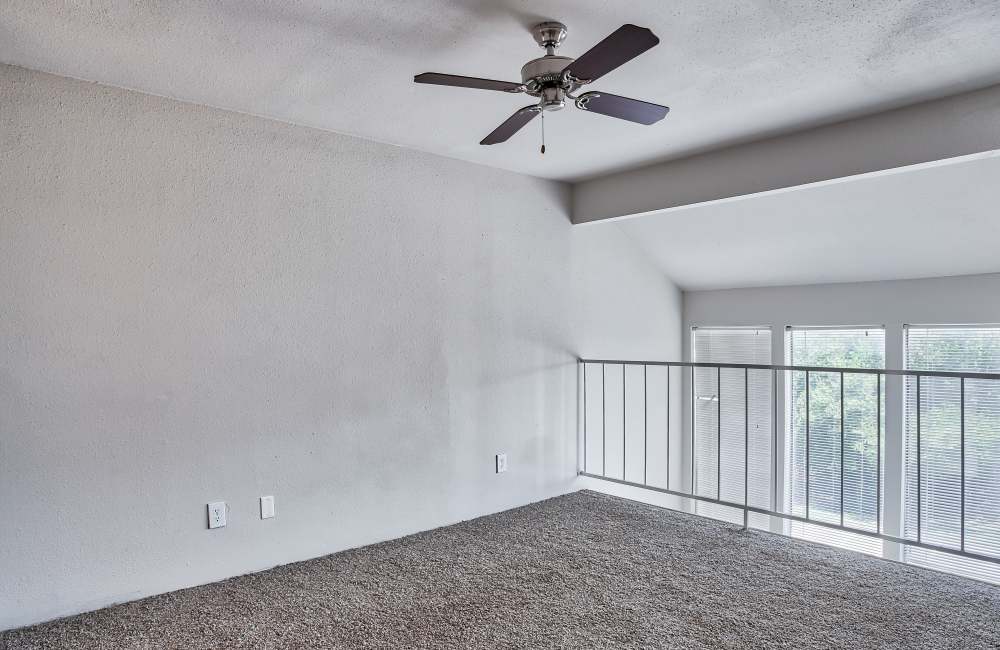 Carpet floored apartment in the upstairs at Branch Creek Apartments in Carrollton, Texas