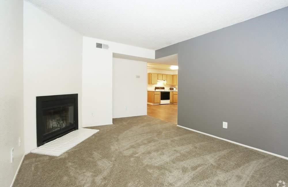 Carpeted living room with fireplace at  River Terrace in Sacramento, California