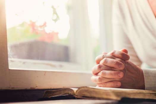 Hands resting on a book near a window at The Alexander in Bend, Oregon