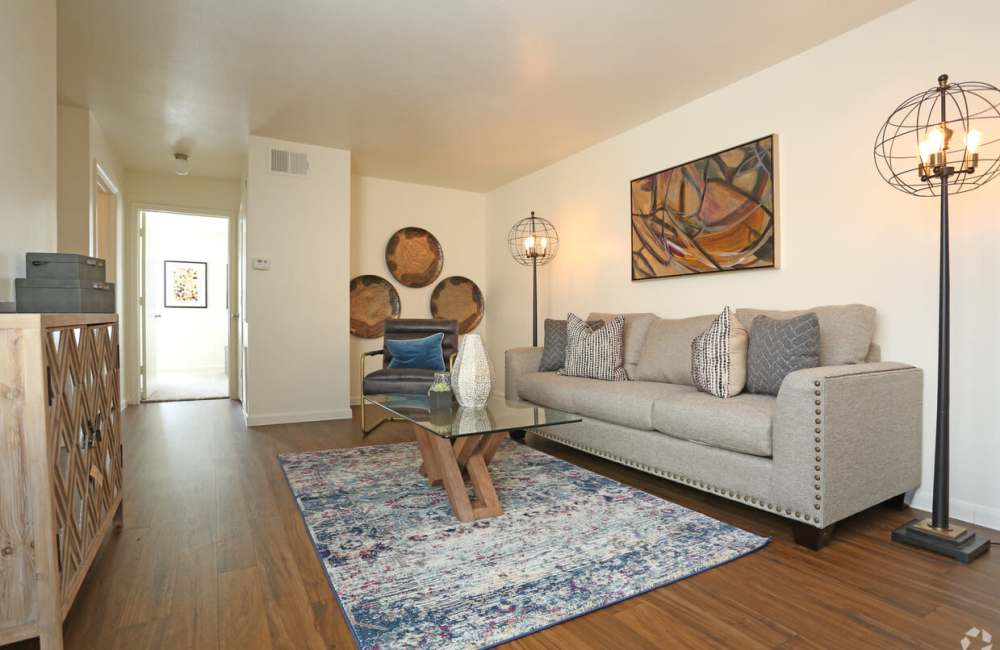 Modern apartment living room with wood-style flooring at Woodforest Chase in Houston, Texas