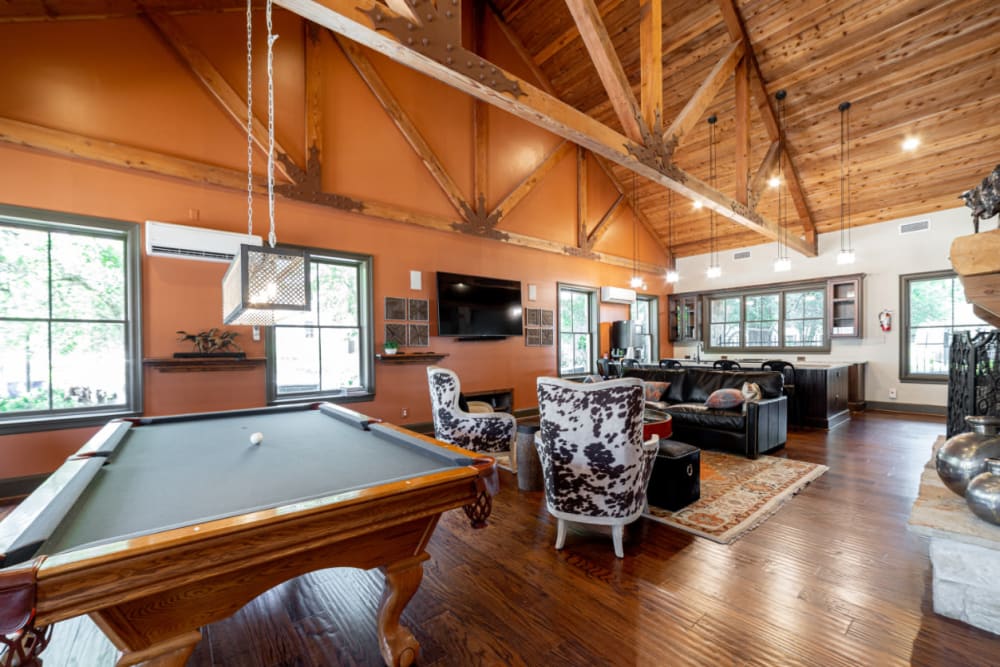 Pool table, seating area, and kitchen in rustic clubhouse at Marquis at Bellaire Ranch in Fort Worth, Texas