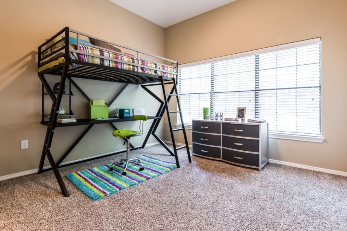 Carpeted bedroom with vaulted ceilings and large windows at Marquis at Waterview in Richardson, Texas