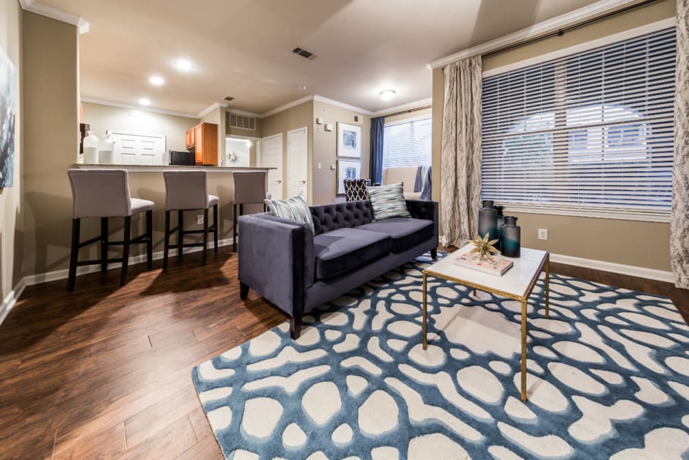 Modern style living room with large window and wood flooring at Marquis at The Cascades in Tyler, Texas