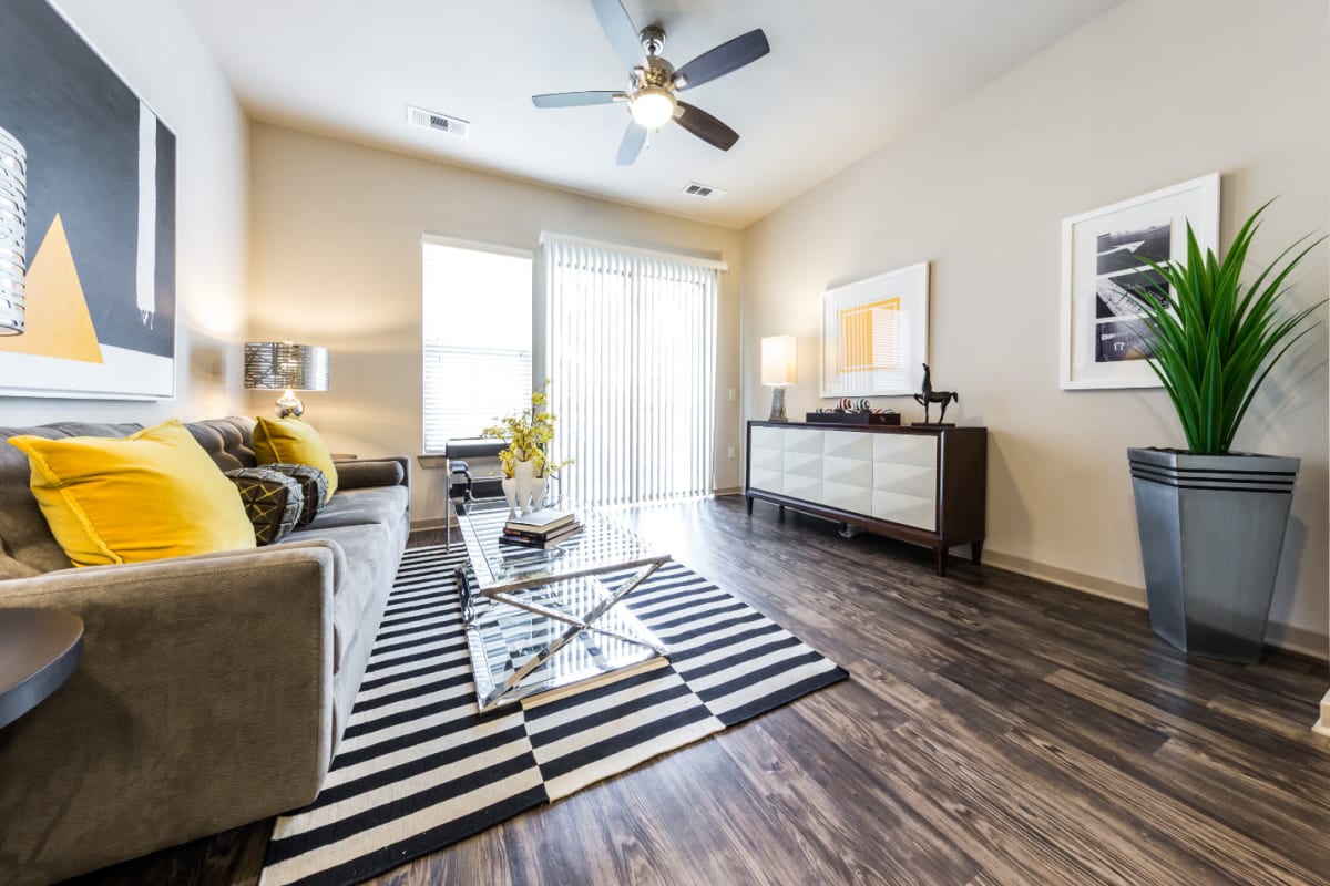 Bright and modern style living room with wood flooring and access to balcony at Marq Uptown in Austin, Texas
