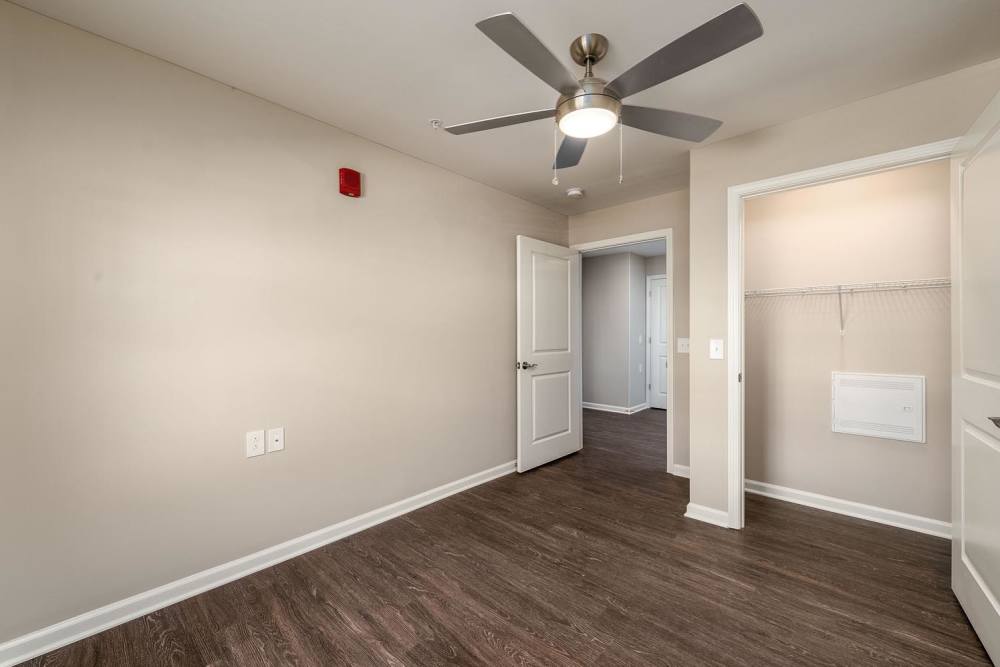 Spacious room with wood-style flooring and ceiling fan, featuring a closet and neutral walls at Owens Greene in Wheeling, West Virginia