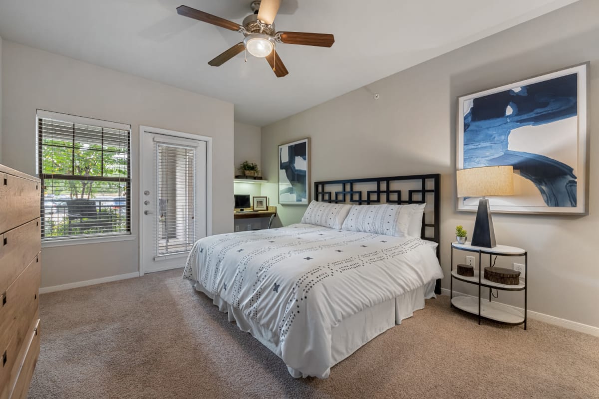 Spacious bedroom with computer nook and access to private balcony at Marquis at Sugar Land in Sugar Land, Texas