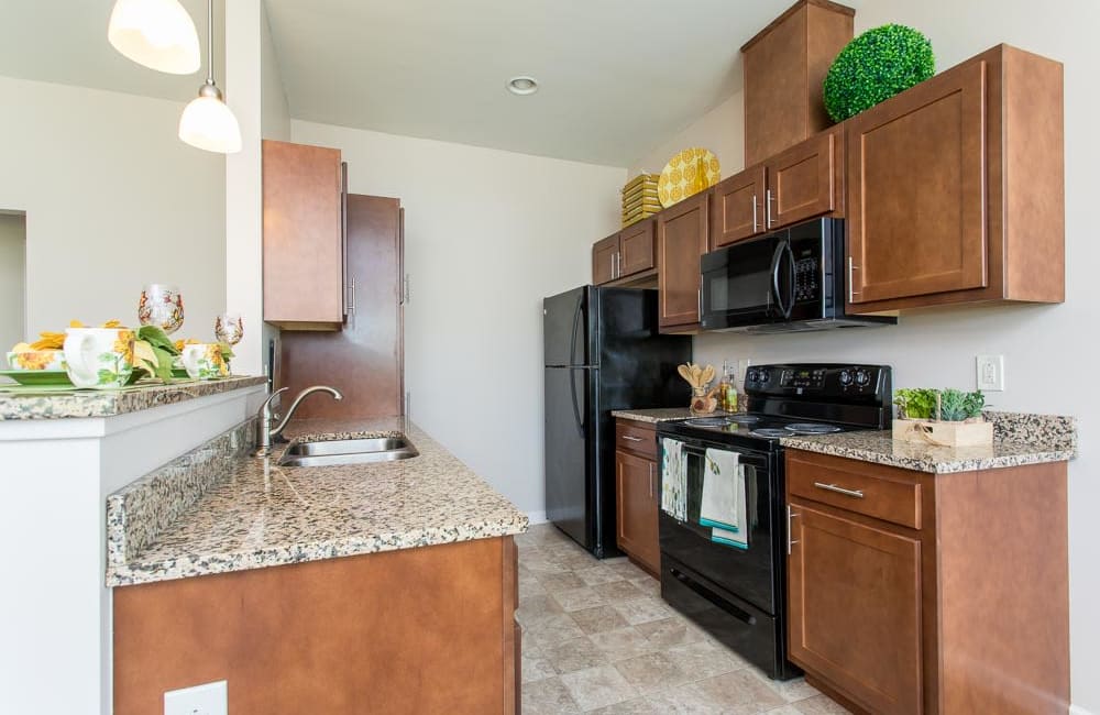 Beautiful white kitchen with a bar at Preserve at Autumn Ridge in Watertown, New York.