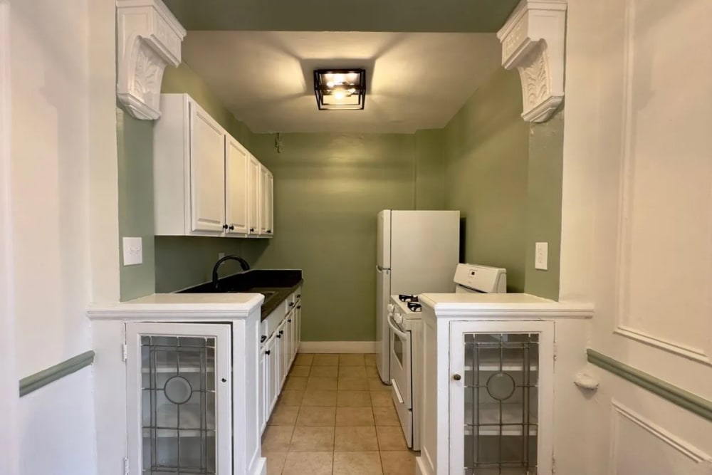 Kitchen with white cabinetry and appliances at Detroit Living in Detroit, Michigan