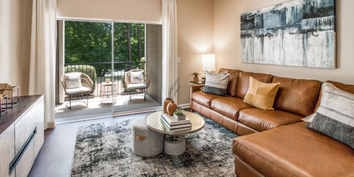 Sleek and modern style living room with private patio at Marquis at Carmel Commons in Charlotte, North Carolina