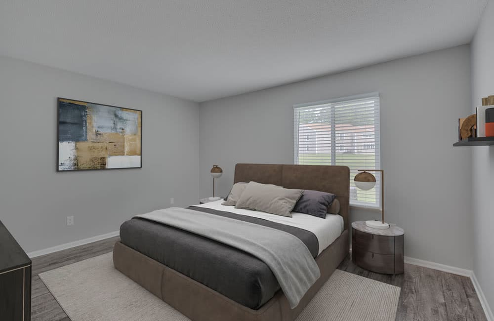 A furnished bedroom with wood-style flooring at The Pointe Apartments in Burlington, North Carolina