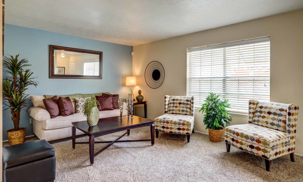 Living room with large windows at Willow Oaks Apartments in Bryan, Texas