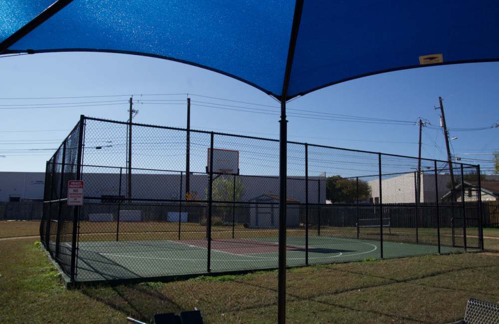 Bright basketball court under a shaded canopy with clear skies at Daffodil in Austin, Texas
